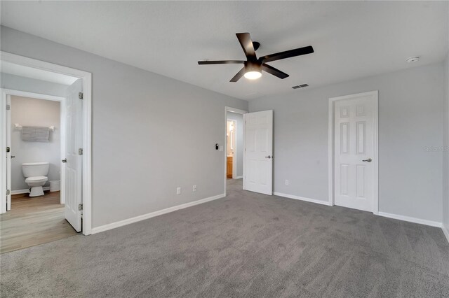2026 Cypress Bay Blvd, Kissimmee, FL 34743 - unfurnished bedroom featuring carpet, connected bathroom, and a ceiling fan