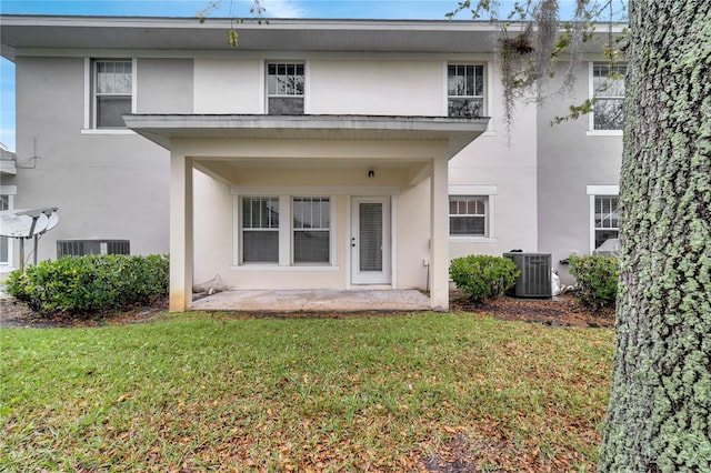 2026 Cypress Bay Blvd, Kissimmee, FL 34743 - rear view of property featuring stucco siding, a lawn, and a patio