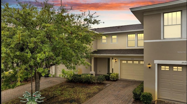 2026 Cypress Bay Blvd, Kissimmee, FL 34743 - townhome / multi-family property with stucco siding, a garage, decorative driveway, and a shingled roof