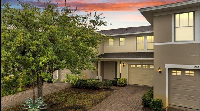 2026 Cypress Bay Blvd, Kissimmee, FL 34743 - multi unit property with stucco siding, a garage, decorative driveway, and a shingled roof
