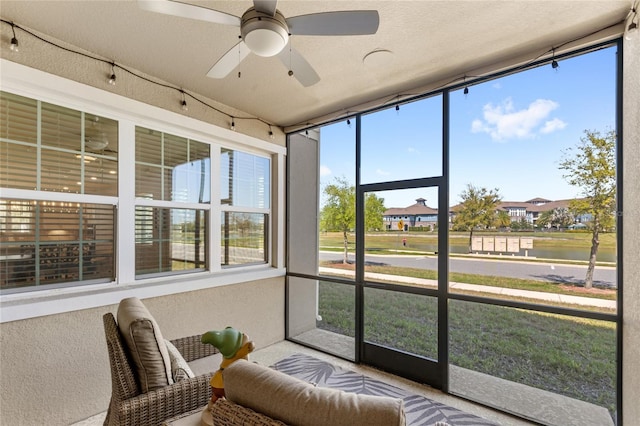 sunroom / solarium featuring ceiling fan and track lighting