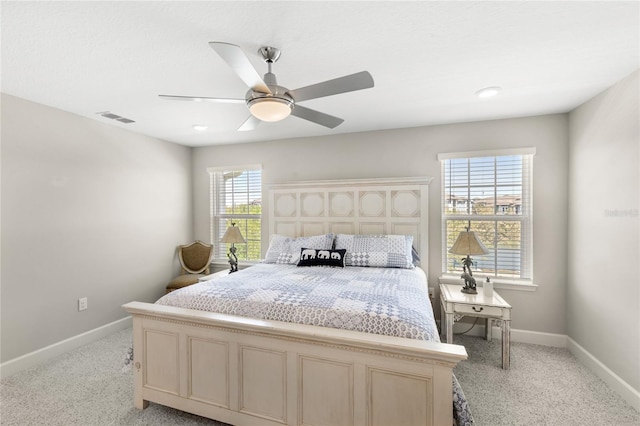 bedroom with visible vents, baseboards, light carpet, and a ceiling fan