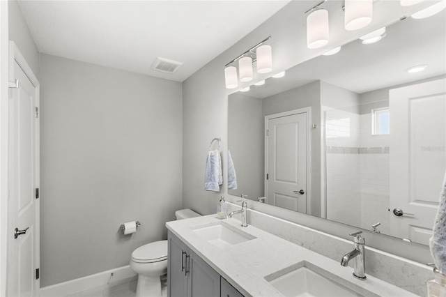 bathroom with visible vents, toilet, baseboards, and a sink