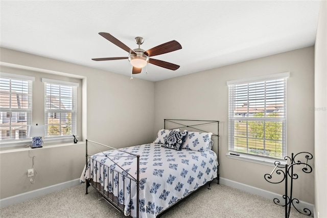 bedroom featuring baseboards, multiple windows, carpet floors, and a ceiling fan