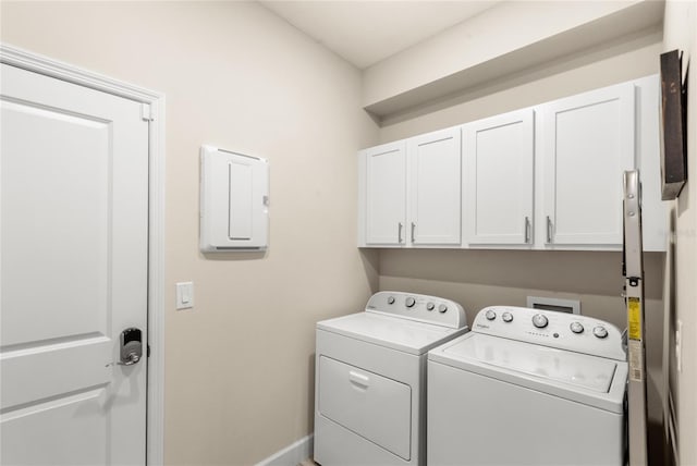 washroom featuring cabinet space, baseboards, and washer and clothes dryer