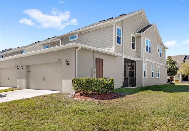 view of side of home featuring a yard, driveway, an attached garage, and stucco siding