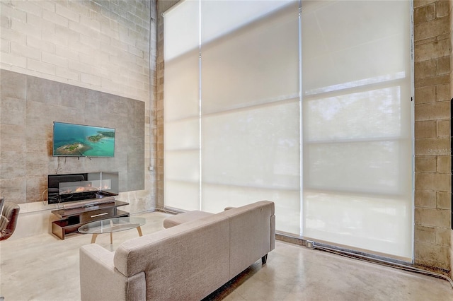 living area with a high ceiling and concrete flooring