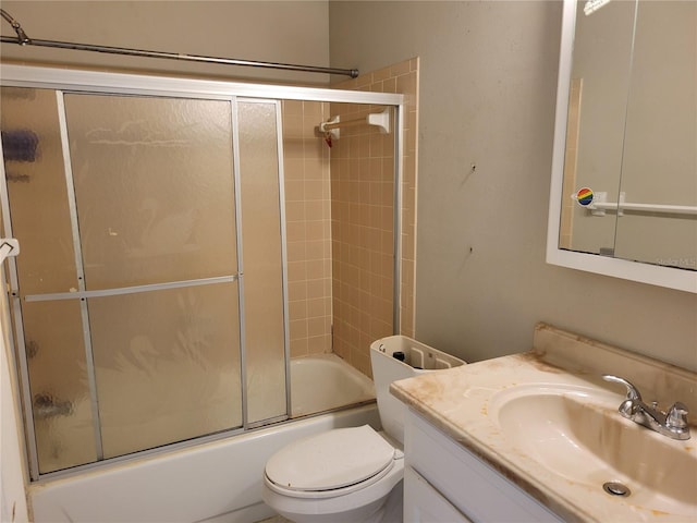 bathroom with combined bath / shower with glass door, toilet, and vanity