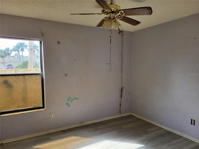 unfurnished room with baseboards, a textured ceiling, wood finished floors, and a ceiling fan