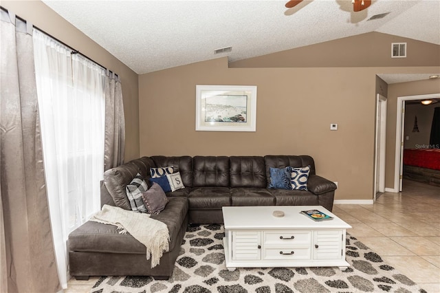 living room with light tile patterned floors, visible vents, and vaulted ceiling