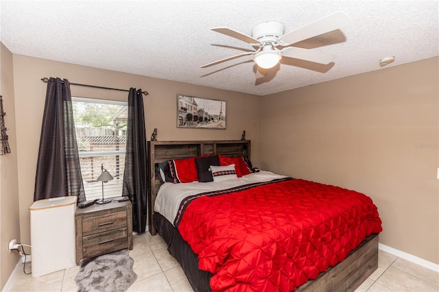 bedroom featuring light tile patterned floors, a ceiling fan, baseboards, and a textured ceiling