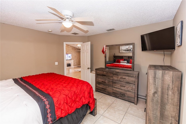 bedroom featuring light tile patterned floors, visible vents, and a textured ceiling