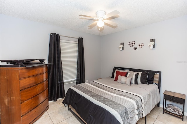 bedroom featuring ceiling fan, light tile patterned flooring, and a textured ceiling