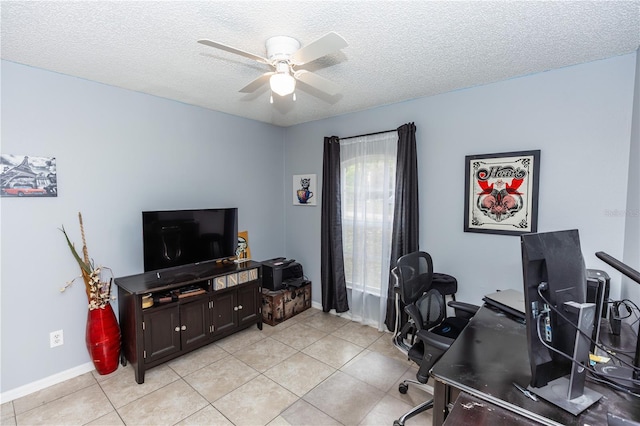 office space featuring light tile patterned floors, a ceiling fan, baseboards, and a textured ceiling