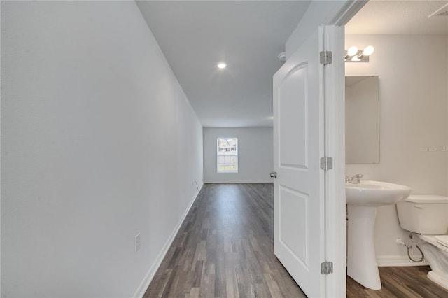 hallway featuring baseboards and wood finished floors