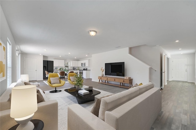 living area featuring recessed lighting, baseboards, and light wood-style flooring