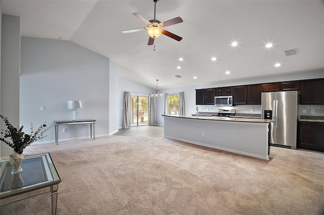kitchen featuring visible vents, lofted ceiling, a sink, stainless steel appliances, and light colored carpet