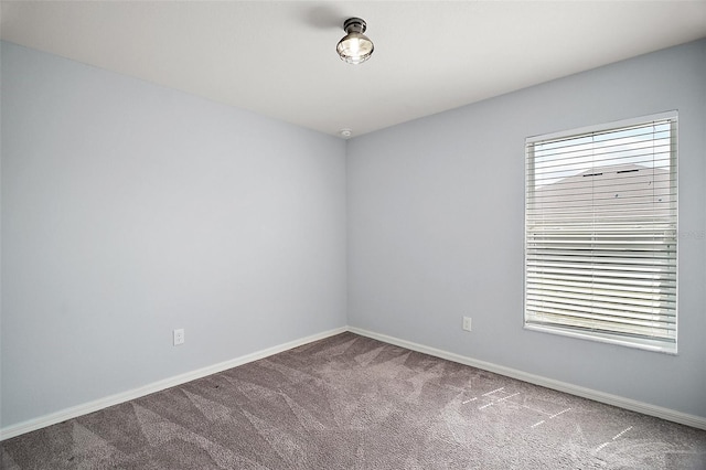 carpeted spare room with baseboards