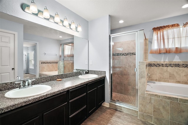 bathroom with a bath, a shower stall, and a sink