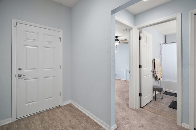 corridor with baseboards, carpet floors, and wood finished floors