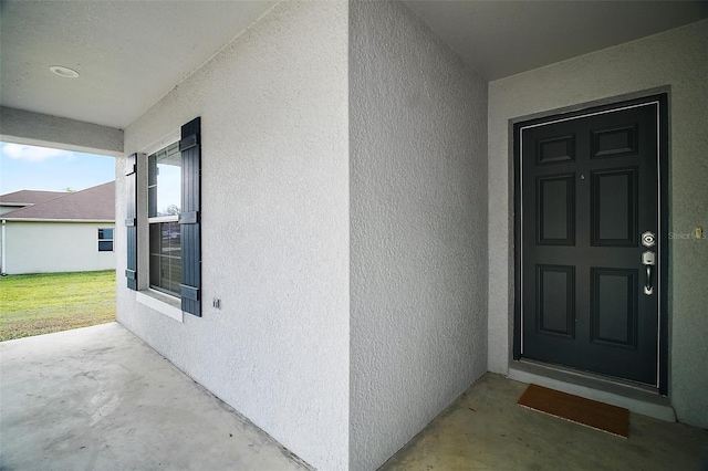 property entrance with stucco siding