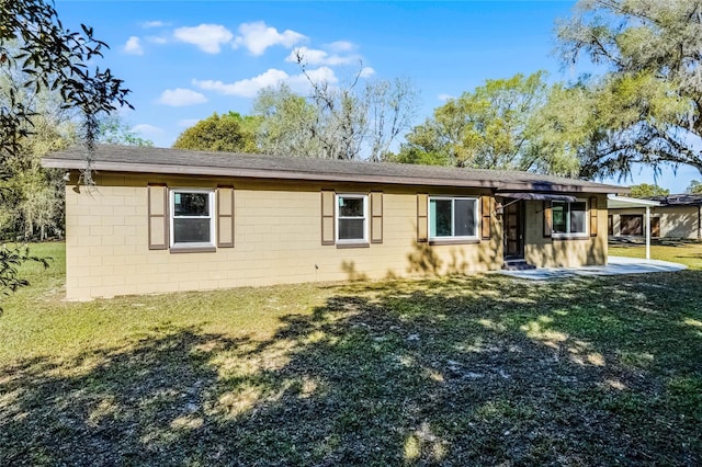 exterior space featuring concrete block siding and a front lawn