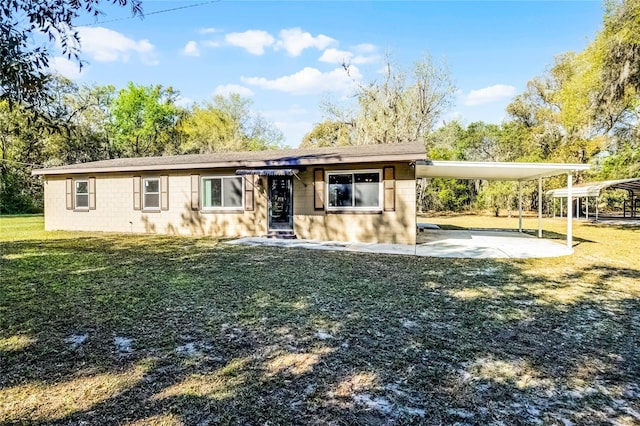 view of front of house with an attached carport, a front lawn, concrete driveway, and concrete block siding