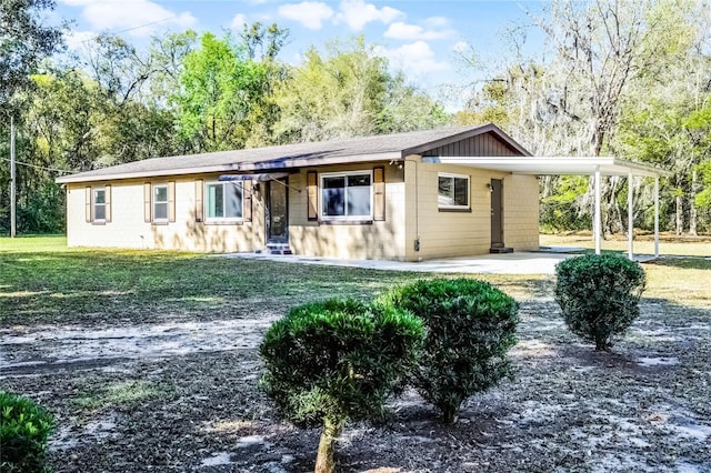 view of front of house featuring an attached carport, driveway, and a front lawn