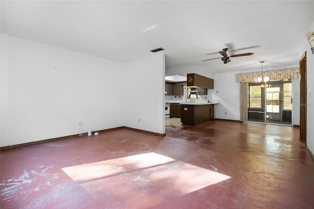 unfurnished living room featuring ceiling fan with notable chandelier, baseboards, and concrete floors