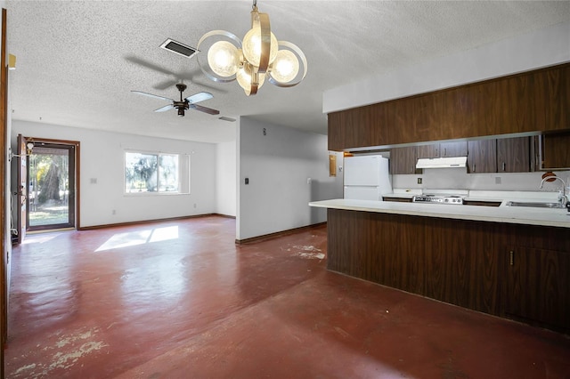 kitchen with under cabinet range hood, finished concrete floors, freestanding refrigerator, stove, and a sink