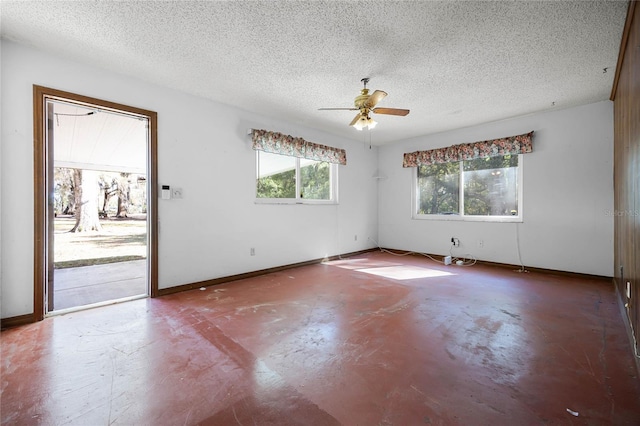 unfurnished room with baseboards, a textured ceiling, concrete flooring, and ceiling fan