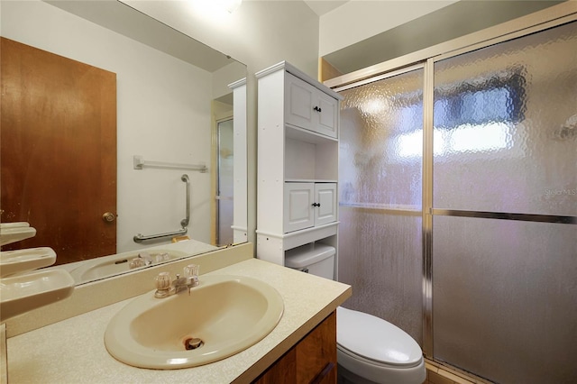 full bath featuring toilet, a shower stall, and vanity