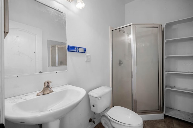 full bath featuring tile patterned flooring, a shower stall, toilet, and a sink