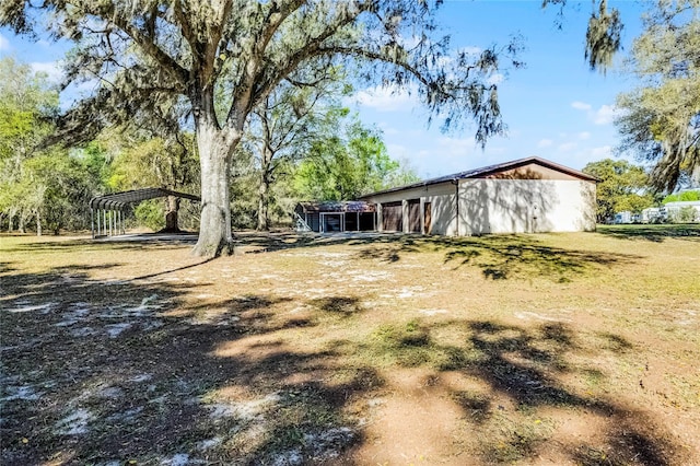 view of yard featuring a detached carport and driveway