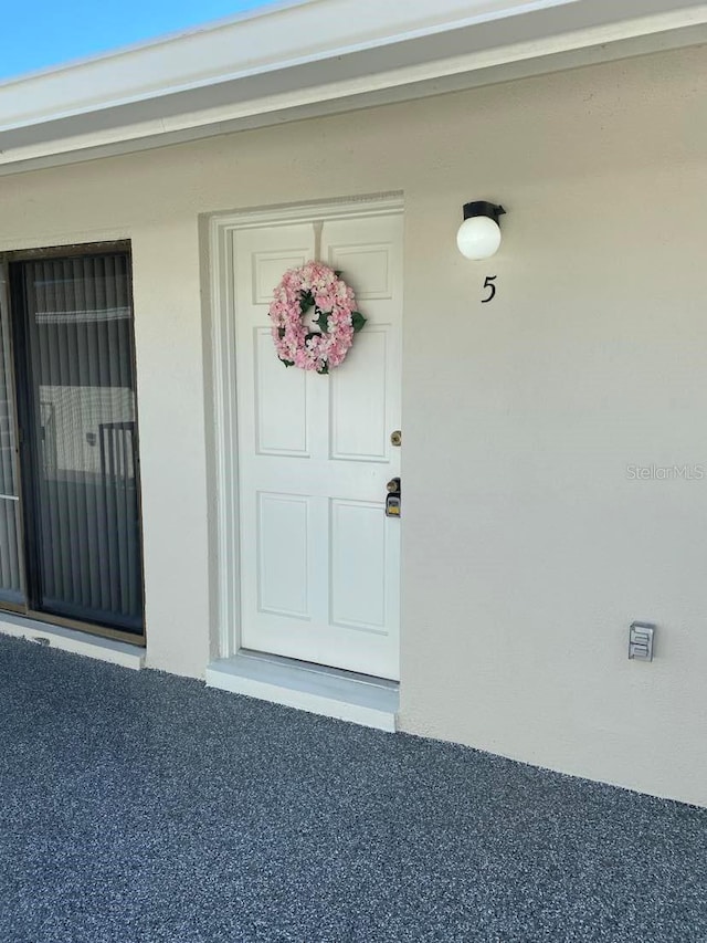 entrance to property featuring stucco siding