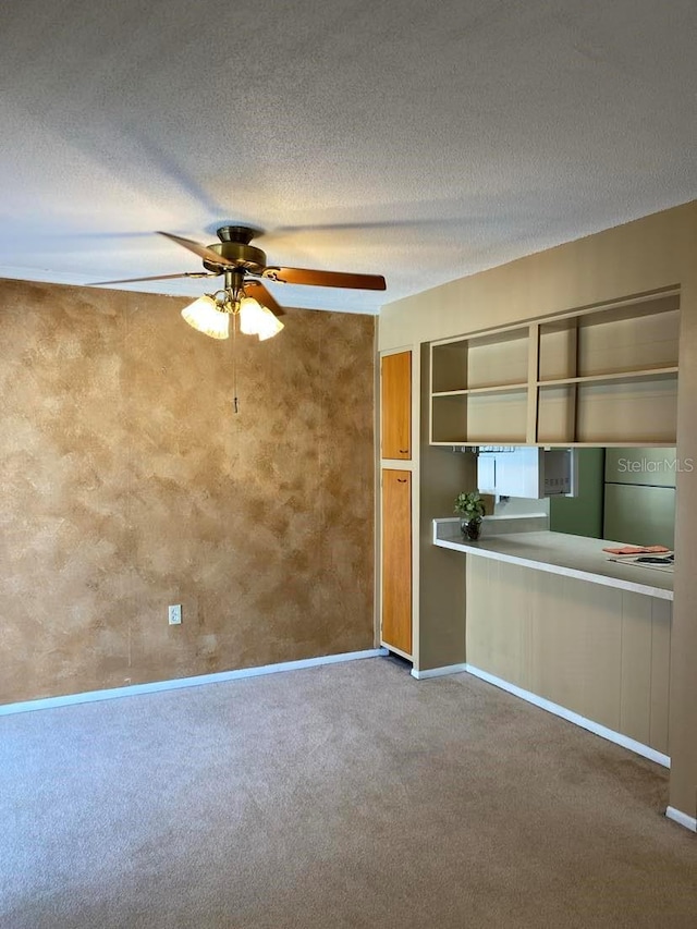 interior space featuring baseboards, a textured ceiling, a ceiling fan, and carpet