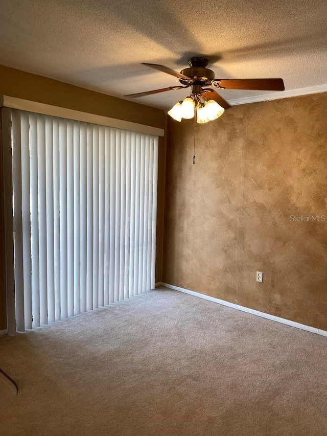 empty room with carpet flooring, a textured ceiling, and a ceiling fan