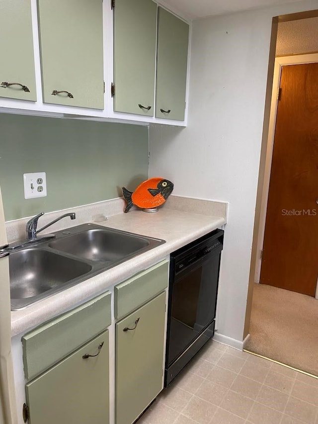 kitchen with dishwasher, light countertops, green cabinets, and a sink