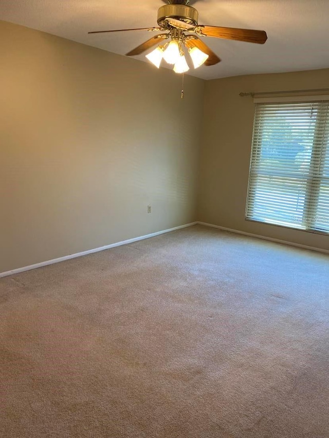 carpeted empty room with baseboards and ceiling fan