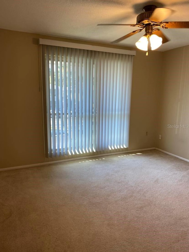 unfurnished room featuring baseboards, a textured ceiling, ceiling fan, and carpet floors