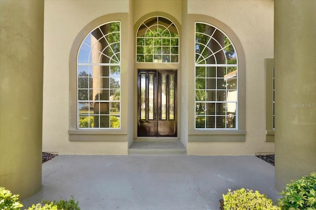 view of exterior entry with stucco siding and french doors