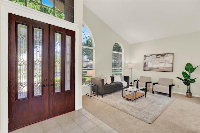 foyer featuring high vaulted ceiling, french doors, baseboards, and light carpet