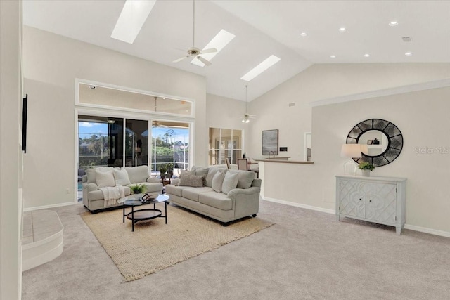 living area with ceiling fan, a skylight, carpet, and high vaulted ceiling