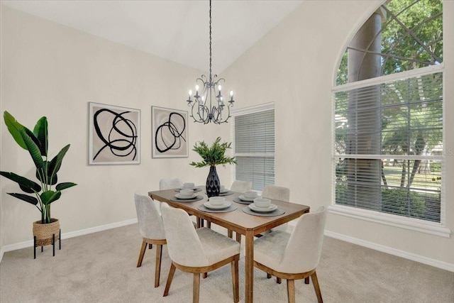 dining space featuring a chandelier, carpet flooring, high vaulted ceiling, and baseboards