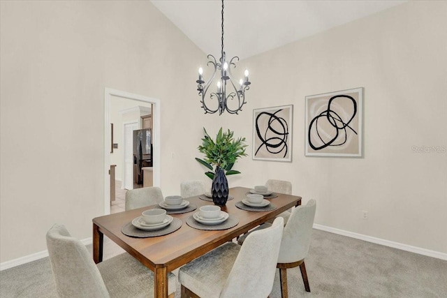 dining area with a chandelier, light colored carpet, baseboards, and lofted ceiling