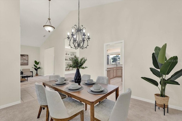 dining area featuring baseboards, high vaulted ceiling, an inviting chandelier, light tile patterned flooring, and light colored carpet