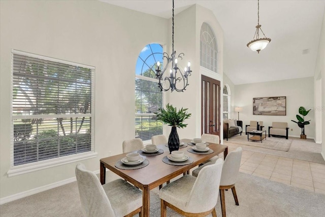 tiled dining area with an inviting chandelier, carpet, baseboards, and high vaulted ceiling