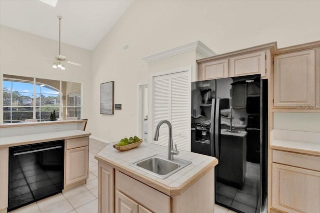 kitchen featuring tile countertops, a ceiling fan, a sink, light brown cabinetry, and black appliances