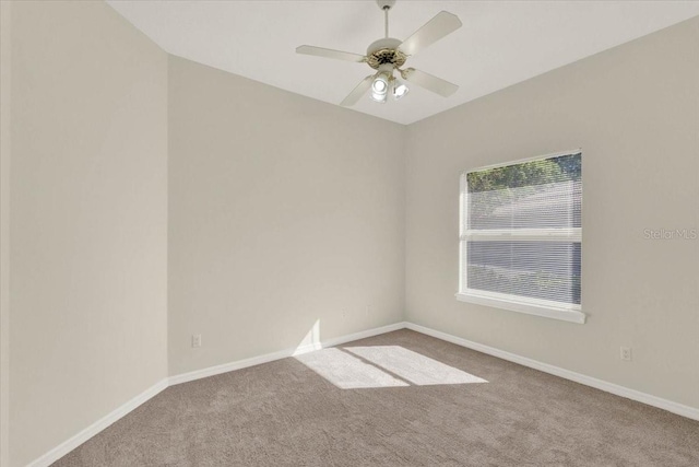 spare room featuring carpet flooring, a ceiling fan, and baseboards