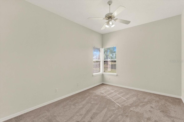 empty room with light carpet, a ceiling fan, and baseboards